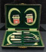 An early 20th century cased manicure set, with vibrant green fitted interior, one tool replaced