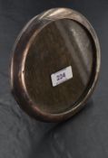A George V silver photograph frame, of circular for with easel stand to reverse, marks for