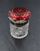 An Edwardian enamelled silver topped dressing table jar, the cushion shaped top enamelled in rich