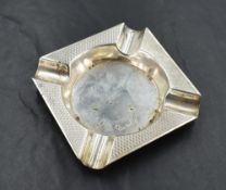 A George VI silver ashtray, of square outline with central circular well enclosed by an engine-