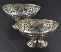 A pair of late Victorian silver pedestal dishes, of oval form with pierced diaper and embossed