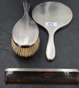 A 1960's silver three-piece dressing table set, comprising hand mirror, hair brush and comb of
