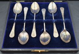 A cased set of six Edwardian silver coffee spoons having extensively engraved stems and plain
