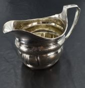 A George III silver cream jug, of helmet form with reeded rim and moulded body with bands of