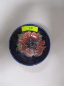 A vintage Moorcroft pin dish having tube lined anemone pattern to cobalt blue ground.