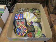 A selection of modern tourist keepsakes including sew on patches, enamel badges and medals