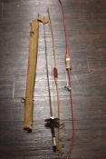 Two 20th century archery bows with a vintage fishing rod and a military swagger stick marked Army