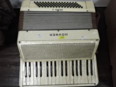 A vintage Hohner Verdi II accordian in a cream colour
