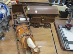 A miniature traditional wooden caravan and ceramic shire horse.