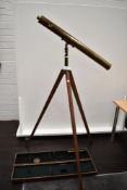 An antique floor standing brass bodied refractor telescope with three inch brass tube