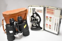 A pair of Super Zenith 12x50 field binoculars with a scientific microscope