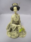 An oriental composite figurine of a lady in traditional dress.