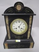 A late 19th/ early 20th century black slate mantel clock having carved detail highlighted with