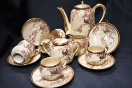 An early 20th century Japanese Satsuma part tea service decorated with Prunus and pheasants
