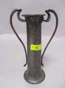 An Art Nouveau pewter vase with Planished finish and shaped handles with flower motifs impressed