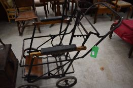 An Edwardian invalid carriage or wheel chair metal frame with rubber wheels
