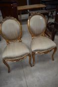 A pair of 19th Century French style formal chairs with overstuffed back and seats, with giltwood