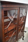 A 19th Century mahogany display cabinet having astral glazed doors, on shaped legs with ball and