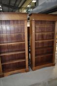 A pair of modern hardwood tall bookcases in the classical style