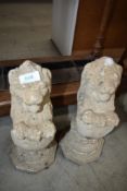 A pair of small concrete lion ornaments