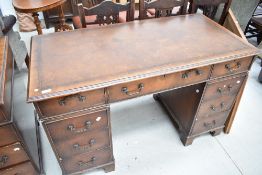 An early 20th century pedestal desk having veneer fronts with brown skiver leather top