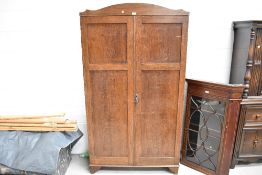 An early 20th Century dark oak wardrobe with shelf and cupboard storage