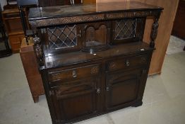 A mid to late 20th century dark oak court cupboard having leaded glazed doors with cupboard and