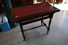 A 19th Century mahogany side table having leather insert, spindle undergallery and turned frame with