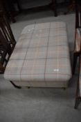 A modern ottoman stool, in tweed style fabric