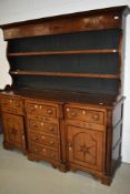 An interesting period oak dresser having rack to back, central drawer section to base, ivory
