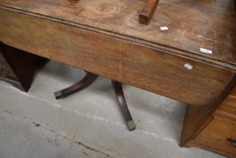 A 19th Century Regency design pedestal table having drop leaf top on turned column and quadruple