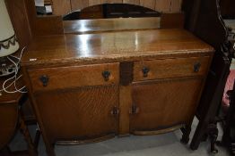 An early 20th Century oak sideboard having low mirror back