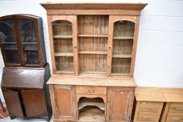 A Victorian stripped pine dresser base and glazed book shelf unit with rolled glass doors