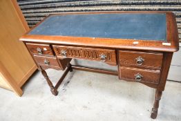 A 20th century kneehole desk in oak with a green leather skiver top