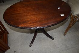 A reproduction occasional table, oval with four splay legs