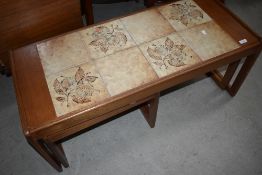 A vintage teak and tile top coffee table with nesting pair under