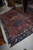 A traditional carpet square having blue and pink ground