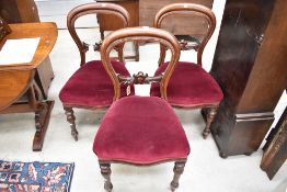 Three Victorian balloon back dining chairs with carved details and turned legs