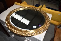 A traditional gilt frame oval wall mirror