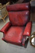 A mid century reclining arm chair or lazy boy having blood red leather