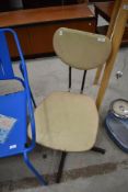 A vintage vinyl office chair on metal swivel frame