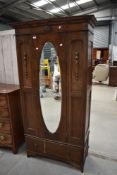 A late 19th or early 20th Century oak mirror door single wardrobe having drawer to base