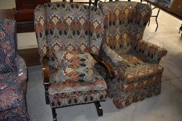 A vintage wingback rocking chair having William Morris style covers and a similar wingback armchair