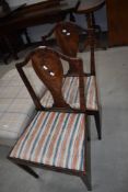 A pair of 19th Century mahogany dining chairs having shaped backs and later upholstered seats