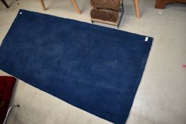 A modern navy blue rug, approx 75 x 150cm
