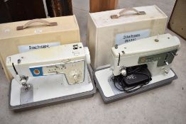 Two modern electric Singer Sewing machines with hard cases