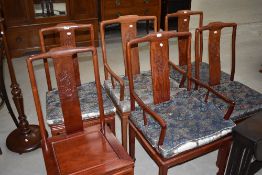 An Oriental hardwood dining table and set of six (four plus two) dining chairs
