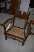 A traditional stained frame low seat carver chair having canework seat