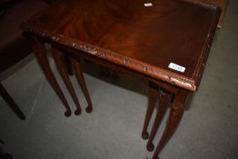 A reproduction mahogany nest of three tables in the period style