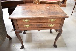 A George III oak low boy having double drawer set with original brass handles and cabriole legs